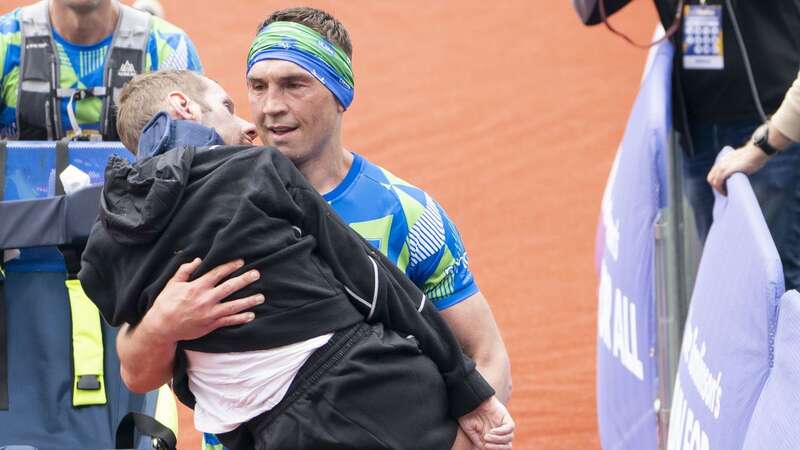 Kevin Sinfield carrying his friend Rob Burrow over the finishing line last year (Image: PA)