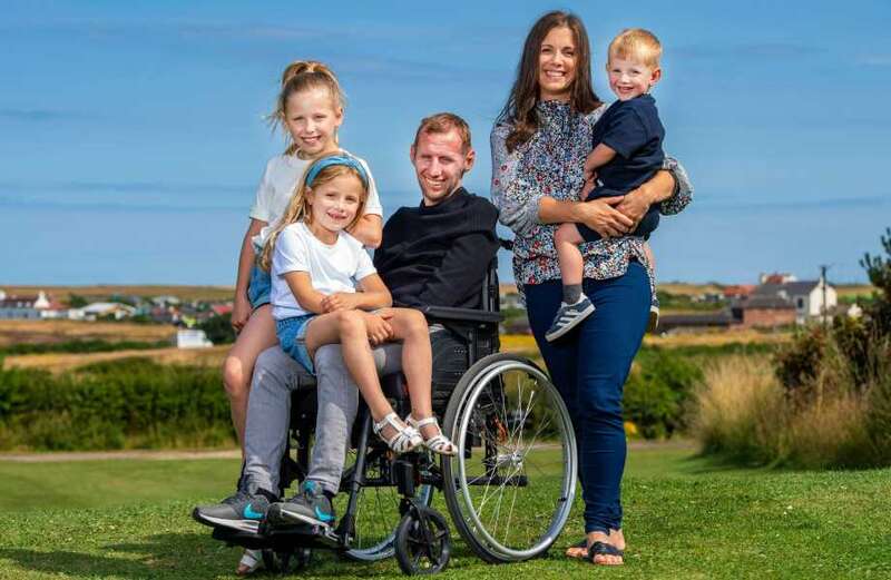 The last photo of Rob shows him smiling with his family at a MND fundraiser