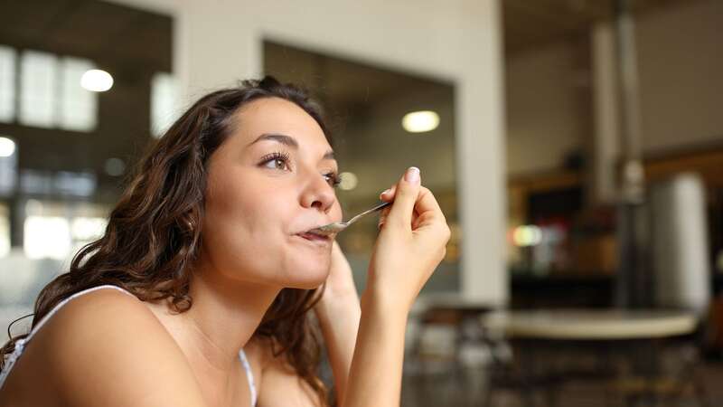 Woman using spoon in a coffee shop (Image: Getty)