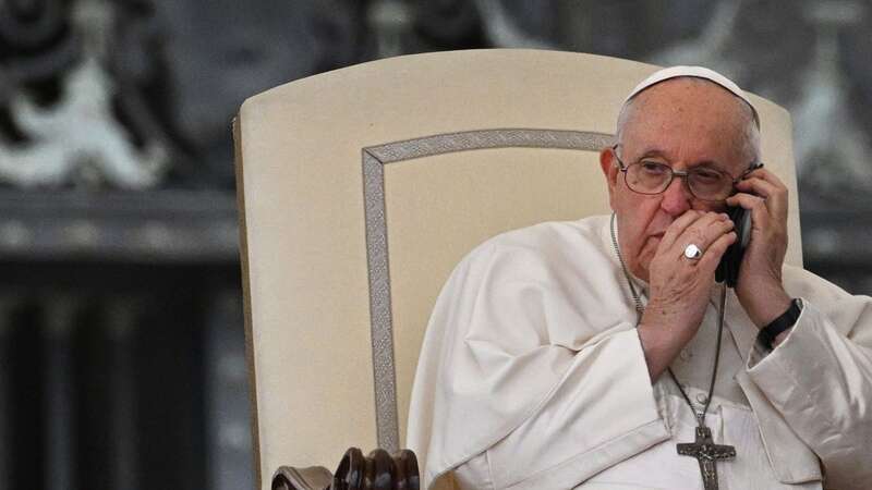 Pope Francis speaks on the phone during the weekly general audience at St. Peter