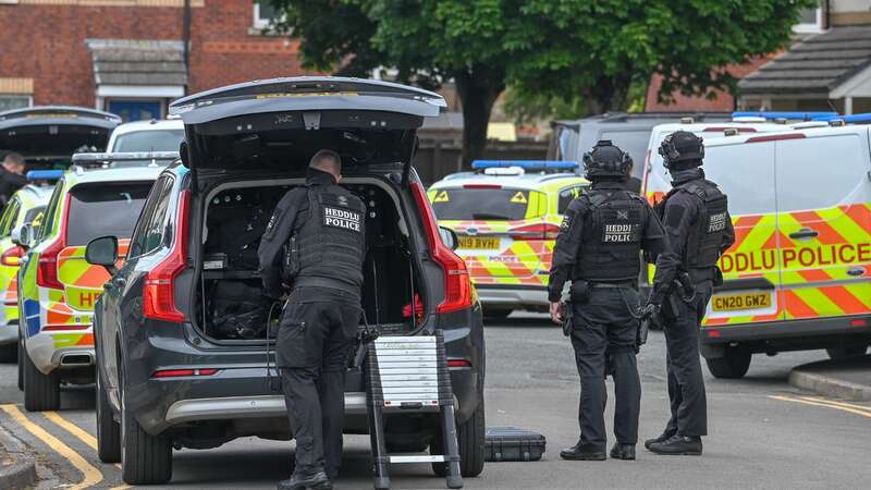 Armed police officers are pictured at the scene on the residential road (Image: Robert Melen)