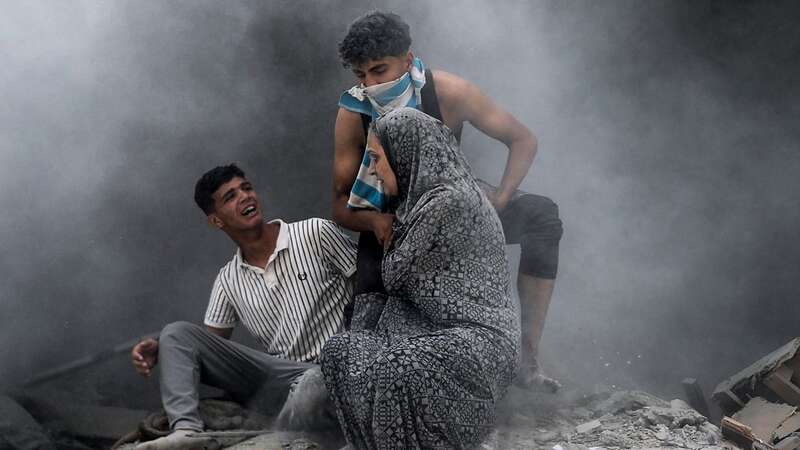 Palestinians walk out of the rubble, covered in dust after the Israeli attack on Abu Aisha family house in Deir al Balah, Gaza on June 14 (Image: Anadolu via Getty Images)