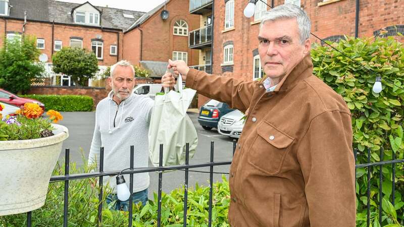 Stuart Booth (left), 66, passing shopping to husband Tony Wass, 67 over the fence (Image: SWNS)