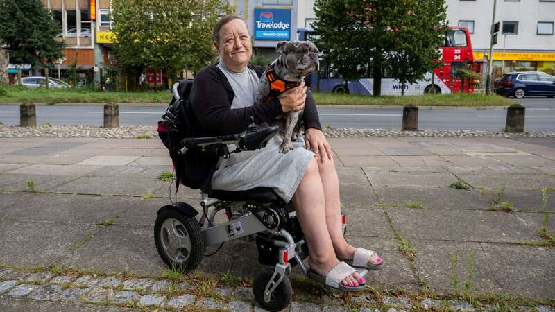 Karen Bishop, 51, with her two-year-old French bull dog Drew outside the Travelodge in Norwich (Image: SWNS)