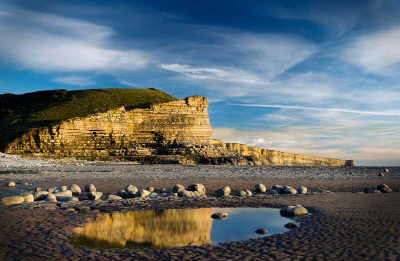 The beach is backed by dramatic cliffs hiding their own secrets