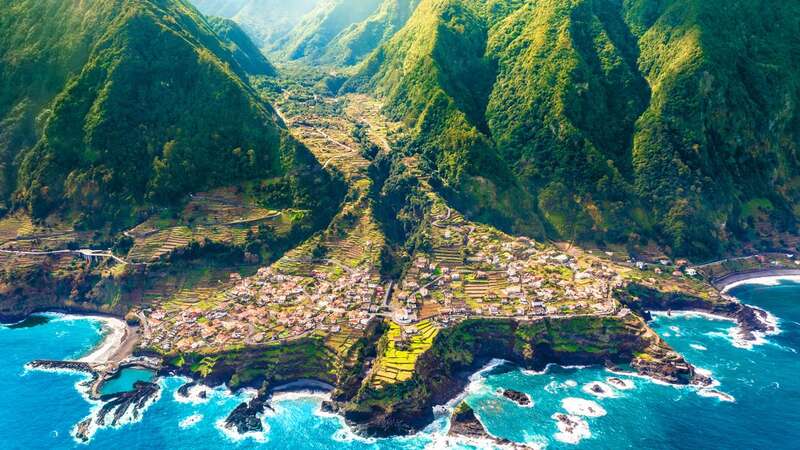 The island is surrounded by green mountains and dazzling blue ocean (Image: Getty Images/iStockphoto)