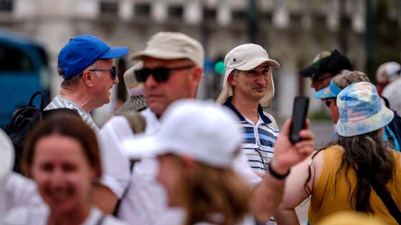 Tourists wear hats to keep off the sun during high temperatures in Athens, Greece - new protocols have been introduced (Image: Getty)