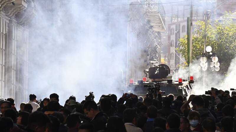 Military troops in armoured vehicles fire tear gas at people outside the Quemado Palace at the Plaza Murillo in La Paz (Image: AFP via Getty Images)