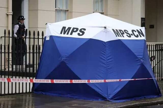 A forensic tent erected outside the home, as a police officer stands guard nearby ( Image: Marcin Nowak/LNP)