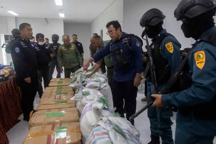 An Indonesian environment ministry official inspects sacks and boxes containing pangolin scales confiscated from suspected smugglers in Medan, North Sumatra (Binsar Bakkara/AP)