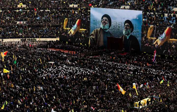 A vehicle carries the coffins of Hassan Nasrallah and Hashem Safieddine in a sports stadium in the southern suburbs of Beirut. Photograph: Thaier Al-Sudani/Reuters