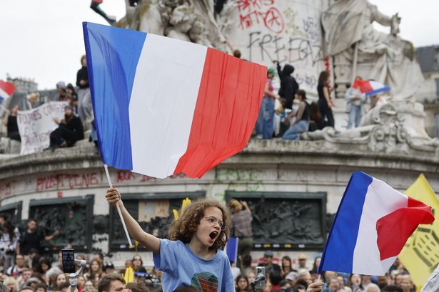 A boy waves a French flag as demonstrators take part in a rally against far-right, at Place de la Republique in Paris on July 3, 2024. (Photo by OLYMPIA DE MAISMONT / AFP) (Photo by OLYMPIA DE MAISMONT/AFP via Getty Images)